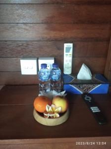 a table with bottles of water and fruit on a plate at Sakya Garden Villa in Toyapakeh
