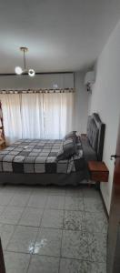 a bedroom with a bed and a couch and a window at Casa Ana 3 departamento a 20 min del aeropuerto de ezeiza in Luis Guillón