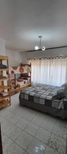 um quarto com uma cama e 2 beliches em Casa Ana 3 departamento a 20 min del aeropuerto de ezeiza em Luis Guillón