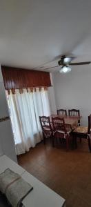 ein Wohnzimmer mit einem Tisch, Stühlen und einer Decke in der Unterkunft Casa Ana 3 departamento a 20 min del aeropuerto de ezeiza in Luis Guillón