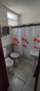 a bathroom with two sinks and a toilet and a shower curtain at Casa Ana 3 departamento a 20 min del aeropuerto de ezeiza in Luis Guillón