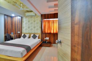 a bedroom with a bed and a table and a door at Townhouse 1307 Coastal Grand Hotels and Resorts in Coimbatore