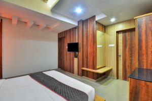 a bedroom with a bed and a tv in it at Townhouse 1307 Coastal Grand Hotels and Resorts in Coimbatore