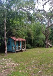 una piccola casa blu in un campo alberato di El Pacará a Vaqueros