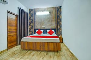 um quarto com uma cama com almofadas vermelhas em OYO HOTEL WINNER INN em Ludhiana