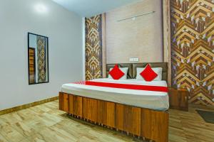 ein Schlafzimmer mit einem großen Bett mit roten Kissen in der Unterkunft OYO HOTEL WINNER INN in Ludhiana
