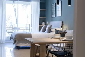 ブエノスアイレスにあるMagnolio Homely Apartmentのベッドルーム1室(ベッド1台、ワイン1杯付きのテーブル付)