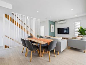 a dining room with a table and a couch at Serenity Sands Townhouse in Kingscliff