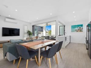 a kitchen and living room with a table and chairs at Serenity Sands Townhouse in Kingscliff
