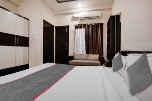 a bedroom with a large bed and a chair at Super Townhouse1306 Hotel Prime Stay in Indore