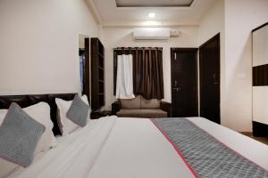 インドールにあるSuper Townhouse1306 Hotel Prime Stayのベッドルーム(大きな白いベッド、椅子付)