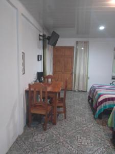 a room with a table and chairs and a bed at Habitacion en Bijagua in Bijagua
