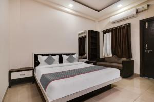 インドールにあるSuper Townhouse1306 Hotel Prime Stayのベッドルーム(大型ベッド1台、椅子付)