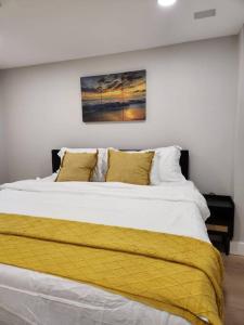 a bedroom with a large bed with a yellow blanket at *The Stunning *King Suite* Heart of Towson in Towson