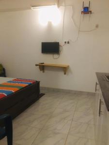 a bedroom with a bed and a tv on the wall at Mango Tree Budget Home Stay in Homagama