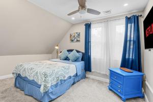 1 dormitorio con 1 cama azul y ventilador de techo en Cozy 4BR, 6beds, 12 guest Home near PHL, UPENN, Fast Wi-Fi, King Bed, Parking en Lansdowne