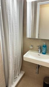 a bathroom with a sink and a shower curtain at Studio hyper centre in Geneva