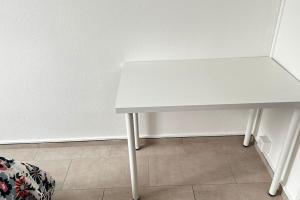 une table blanche assise à côté d'un mur blanc dans l'établissement Studio hyper centre, à Genève