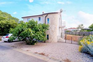 un coche blanco estacionado frente a una casa en Family friendly house with a swimming pool Garica, Krk - 19507 en Kras