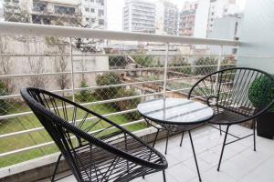 2 chaises et une table sur un balcon dans l'établissement Cedro Comfort Suite, à Buenos Aires