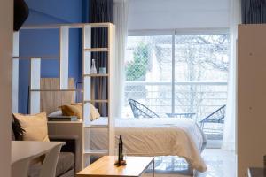 - une chambre avec un lit et une grande fenêtre dans l'établissement Cedro Comfort Suite, à Buenos Aires