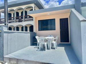 - une table et des chaises sur la terrasse couverte d'une maison dans l'établissement Pé na areia! Aconchegante casa frente Mar, à Governador Celso Ramos
