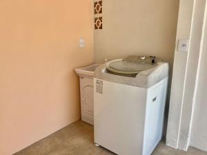 a laundry room with a sink and a washing machine at Pé na areia! Aconchegante casa frente Mar in Governador Celso Ramos