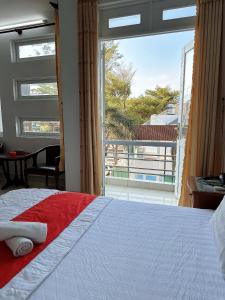 a bedroom with a bed and a large window at GOLDEN TWO Hotel in Vung Tau