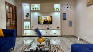 salon z niebieską kanapą i telewizorem w obiekcie Magnifique appartement meublé à Dakar, Rte de Rufisque w mieście Dakar
