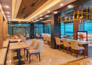 a restaurant with tables and chairs and windows at Seaside Jomtien Beach Pattaya in Jomtien Beach