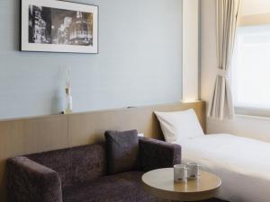 a hotel room with a couch and a bed at Hotel Gracery Ginza in Tokyo