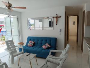 sala de estar con sofá azul y sillas en Fresco y Cómodo Apartamento En Aqualina Orange Girardot, en Girardot