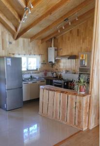 a kitchen with a stainless steel refrigerator and a stove at La Lomita Guadal in Puerto Guadal