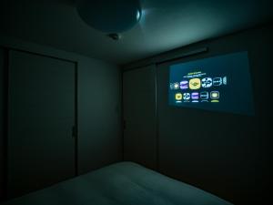 a room with a bed and a screen on the wall at Rakuten STAY HOUSE x WILL STYLE Fujinomiya in Fujinomiya