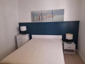 ein Schlafzimmer mit einem Bett und zwei Nachttischen mit zwei Lampen in der Unterkunft Maison Arcachon, 3 pièces, 5 personnes - FR-1-319-126 in Arcachon