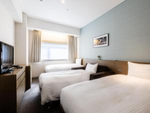 Postel nebo postele na pokoji v ubytování Hotel Gracery Ginza
