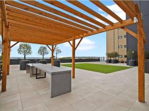 a wooden pergola with benches on a patio at 2 Bedrooms Aptmt with Ocean View in Geelong