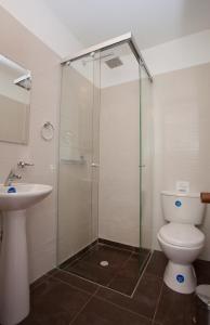 a bathroom with a toilet and a glass shower at Arche Noah Boutique Hostel in Bogotá