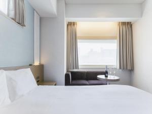 Postel nebo postele na pokoji v ubytování Hotel Gracery Ginza