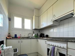 una cocina con armarios blancos y fregadero en Apartamento Sant Pere Pescador, 2 dormitorios, 5 personas - ES-89-114, en Sant Pere Pescador