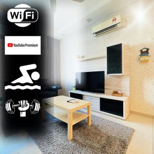 a living room with a tv and a coffee table at Senai Garden Apartment near Senai Airport&JPO 