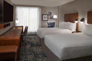 a hotel room with two beds and a desk at Four Points by Sheraton Hotel & Conference Centre Gatineau-Ottawa in Gatineau