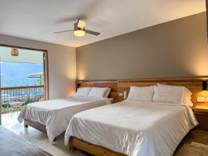 two beds in a bedroom with a balcony at Finca del Café - Casa Bourbon in Santa Rosa de Cabal
