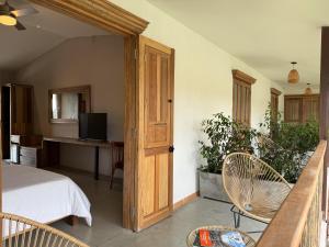 a bedroom with a bed and a desk with a television at Finca del Café - Casa Bourbon in Santa Rosa de Cabal