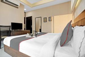 1 dormitorio con 1 cama blanca grande y TV en Townhouse 531 city centre hotel, en Noida