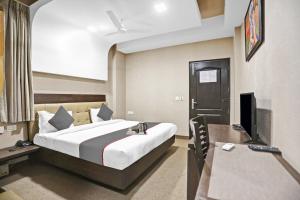 Habitación de hotel con cama y TV en Townhouse 531 city centre hotel, en Noida