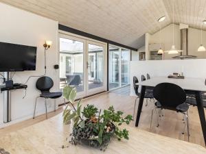 a dining room with a table and chairs and a tv at 8 person holiday home in Hirtshals in Hirtshals