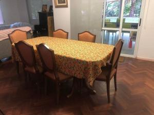 a dining room table with chairs and a floral table cloth at Casa Pilar in Yerba Buena