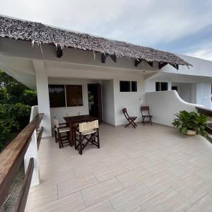 a patio of a house with a table and chairs at Angelina Villas_R1_Arte Casa_Malapascua in Logon