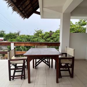 una mesa de madera y 2 sillas en el porche en Angelina Villas_R1_Arte Casa_Malapascua, en Logon
